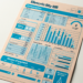 An electricity bill document with blue graphical elements on a beige background. The layout includes consumption data, usage graphs, charges breakdown, means of payment, and a total amount due. The design is visually structured with various charts and numerical details. | MONEY6X
