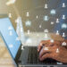 Hands typing on a laptop keyboard, with a visual overlay of interconnected network icons representing an online community. The softly blurred background hints at the theme of digital communication and social networking. | MONEY6X