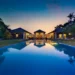 Luxurious villa in Bali at dusk with a long, illuminated pool reflecting the vibrant evening sky. The villa comprises multiple buildings, surrounded by Indonesian trees and ambient lighting, creating a serene and inviting atmosphere. | MONEY6X