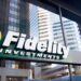 Storefront with a large sign above it displaying "Fidelity Investments" with their logo. Reflective glass windows show the reflections of surrounding modern office buildings and the sky. The Fidelity logo, known for its expertise in Exchange-Traded Funds, is a white abstract design within a yellow circle. | MONEY6X