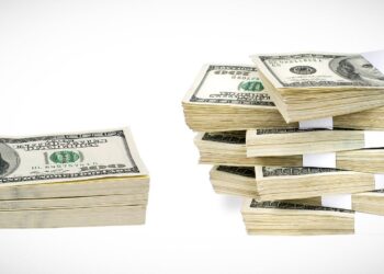 A photo showcases multiple stacks of U.S. hundred-dollar bills. On the left, there is a smaller stack lying flat, while the right side features several larger money stacks, bound with white paper bands, arranged vertically. | MONEY6X