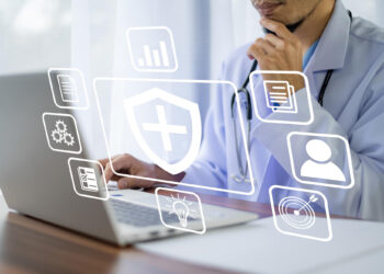A person in a lab coat, possibly a doctor, works on a laptop. Overlay icons indicate healthcare and technology elements such as a shield with a cross, a profile, a document, gears, and a light bulb, suggesting health informatics or telemedicine as well as software solutions for general insurance. | MONEY6X