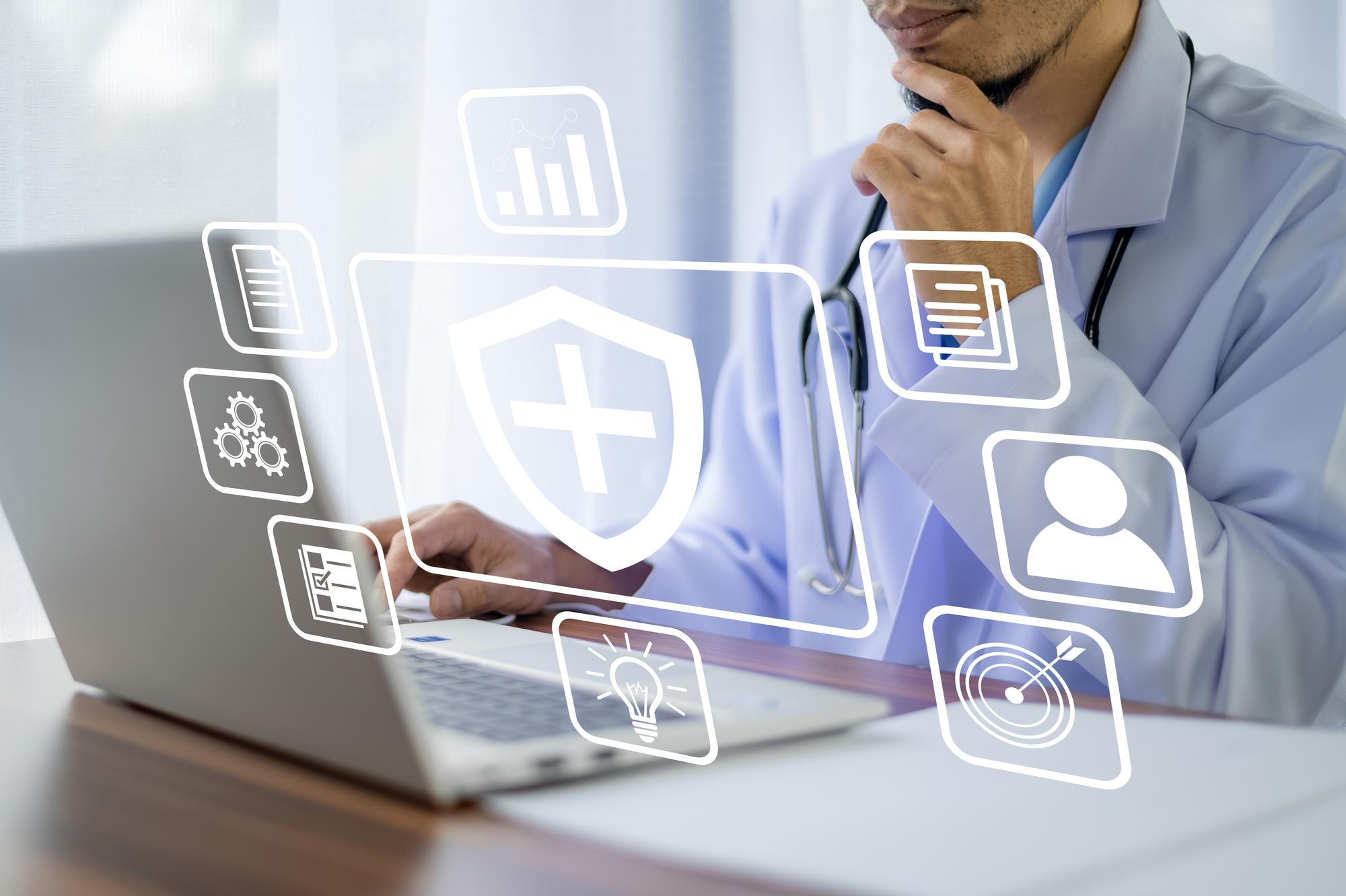 A person in a lab coat, possibly a doctor, works on a laptop. Overlay icons indicate healthcare and technology elements such as a shield with a cross, a profile, a document, gears, and a light bulb, suggesting health informatics or telemedicine as well as software solutions for general insurance. | MONEY6X