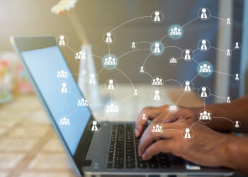 Hands typing on a laptop keyboard, with a visual overlay of interconnected network icons representing an online community. The softly blurred background hints at the theme of digital communication and social networking. | MONEY6X