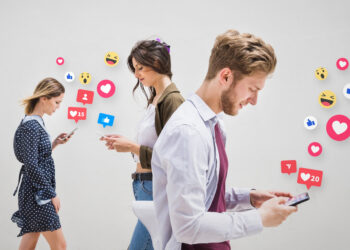 Three people walk while looking at their phones, surrounded by floating social media icons and notifications like hearts, likes, and emojis. This scene illustrates how using social media for your business can boost digital engagement and interaction. | MONEY6X