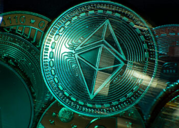 Close-up of various cryptocurrency coins with a prominent Ethereum coin radiating at the center. The intricate patterns on the coins are bathed in a greenish glow, evoking a futuristic digital theme. | MONEY6X