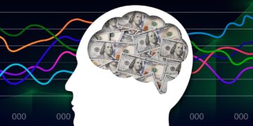 Silhouette of a human head with a brain filled with 100-dollar bills, set against a background of colorful financial line graphs.