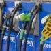 Four gas pumps at a station, with some nozzles covered by yellow “Sorry out of use” signs, indicating they are not available for fueling. The pumps are blue and display the word “synergy.”. | MONEY6X