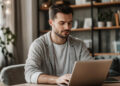 A man working on a laptop at a wooden desk. | MONEY6X